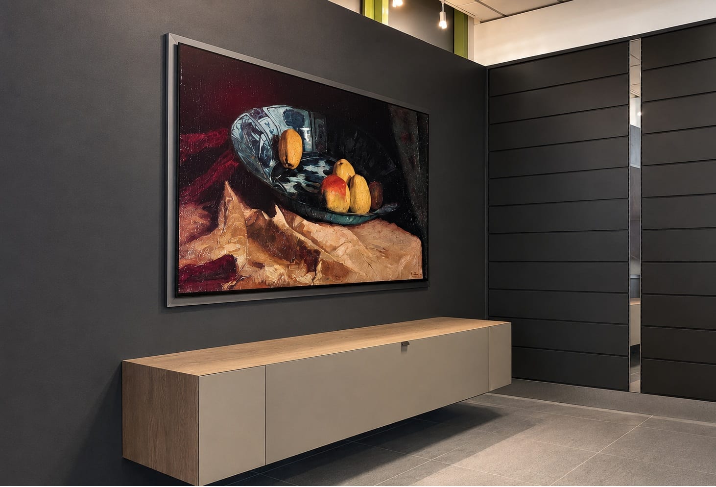 Wand-TV mit Kunstmotiv über schwebendem Lowboard an der dunklen Möbelwand im Showroom